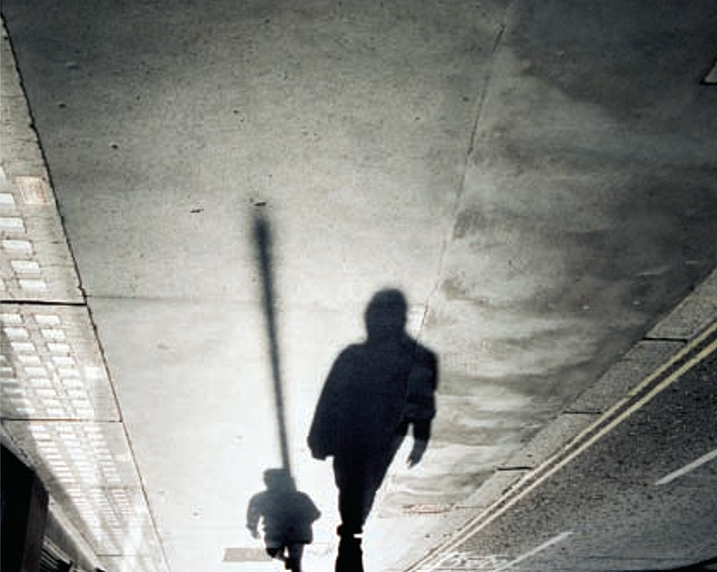 Black and white still image from Mark Lewis's Rush Hour, Morning and Evening (2003), in which two pedestrians' shadows are seen upside down