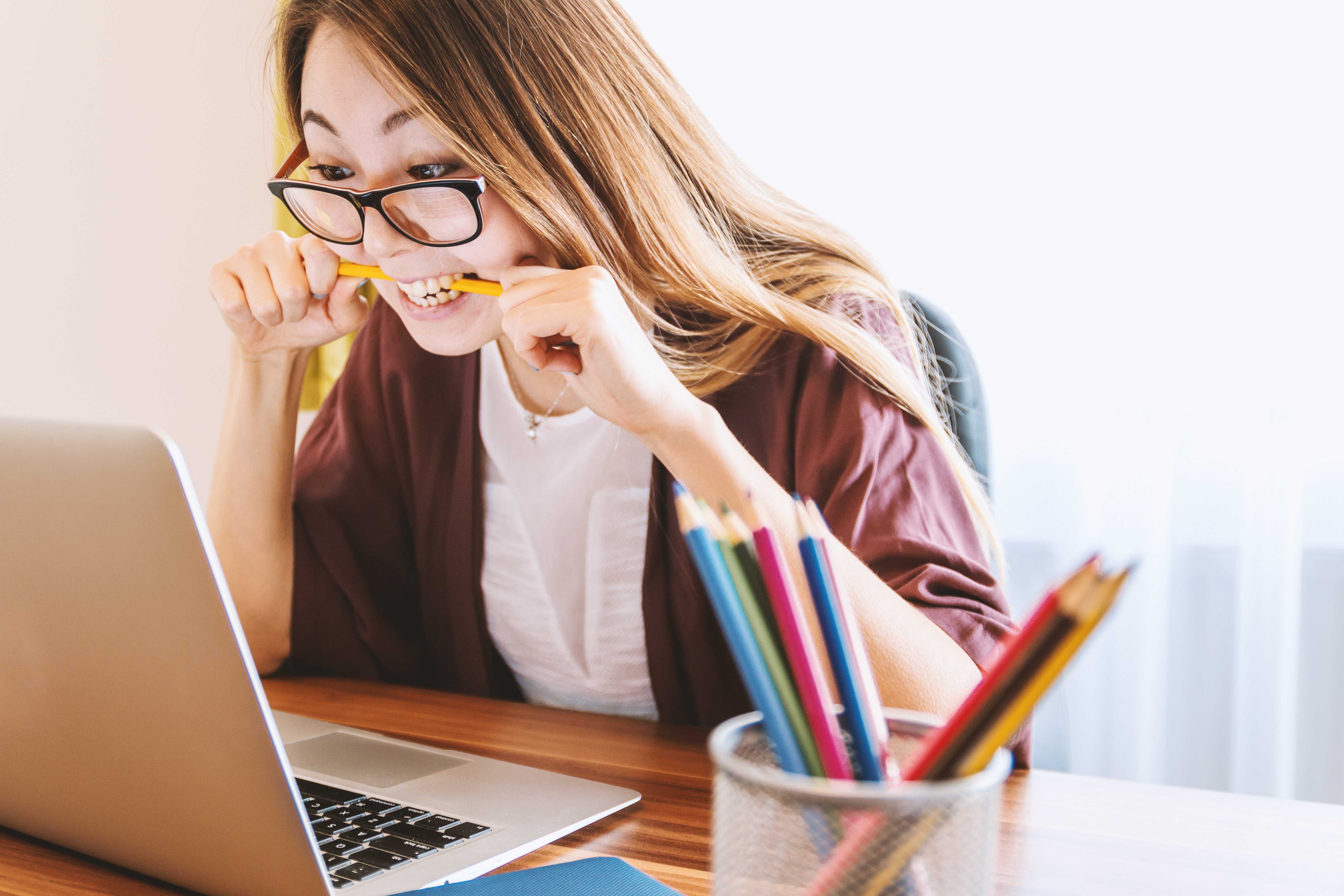 Woman biting a pencil while taking a test