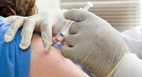 Image of a needle being inserted into a person's arm.