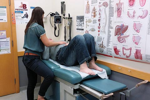 A U of T medical student examines a patient at the IMAGINE clinic.