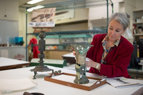 Susan Stock re-assembling and evaluating fragments of a late Shang Dynasty bronze ritual wine vessel. Photo by Mike Fergusson (ROM ID # 960.234.21)