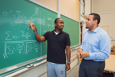 Photo of Akingbade and Okafor at a blackboard in the classroom.