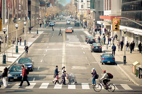 Photo of people crossing a busy city street.