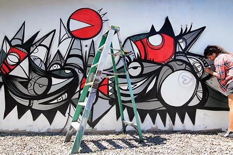 Photo of Fathima Mohiuddin working on her mural 