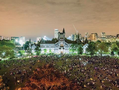 Evening photo of a large crowd of spectators at King's College Circle