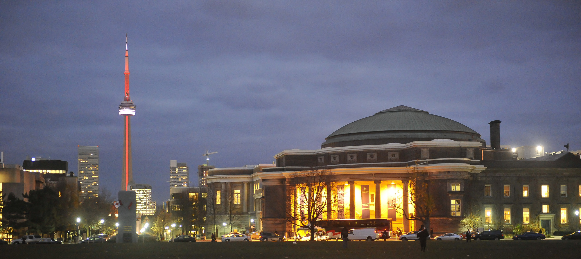 Photo of Toronto skyline at night with CN Tower and Convocation Hall.