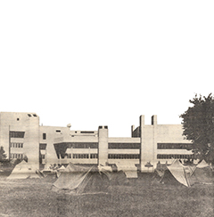 Photo of tents on a field against the backdrop of a UTM building