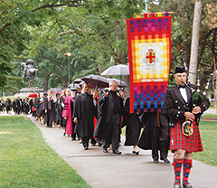 Photo of the convocation procession from Victoria College with bagpiper Rory Sinclair at the lead