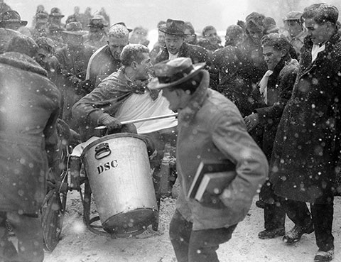 Photo of a chariot race team surrounded by onlookers and snow falling