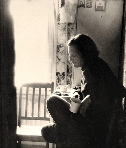 Photo of Soviet poet Oleg Okhapkin sitting in his kitchen