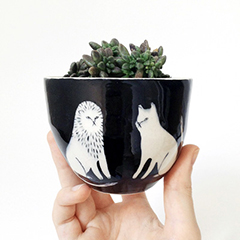 Photo of a cup with black and white designs of a lion and a cat