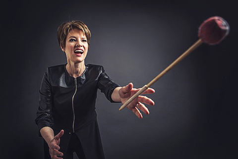 Photo of Beverley Johnston with hands out and a mallet in the air