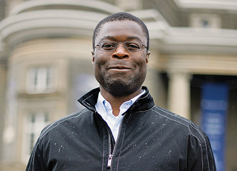 Close-up photo of Carl Mitchell with Convocation Hall in the background