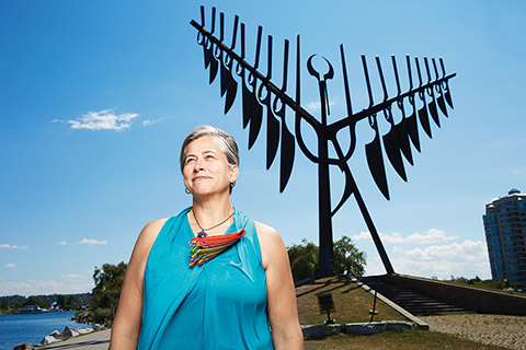 Outdoor photo of Margaret Froh standing in front of Barrie's Spirit Catcher sculpture