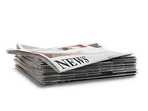 Photo of a stack of newspapers with the headline 