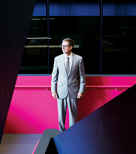 Photo of Tiff Macklem standing on the platform between two staircases