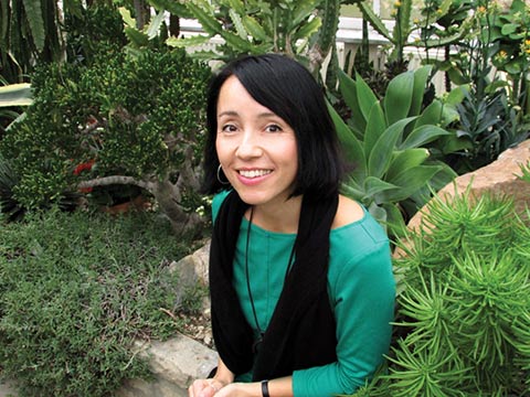 Close-up photo of Kyo Maclear in a garden