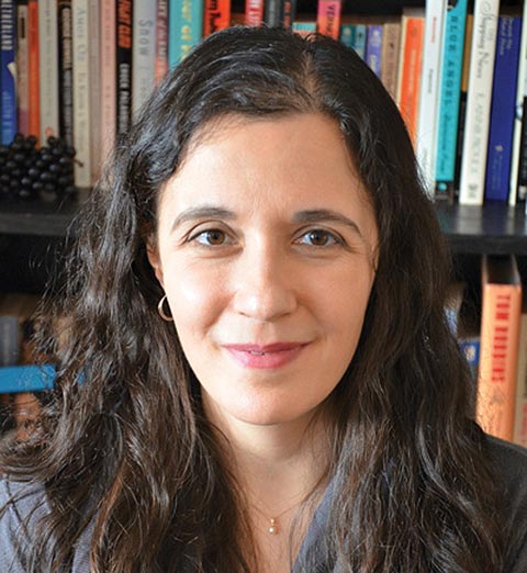 Headshot of Rebecca Rosenblum in front of a bookshelf