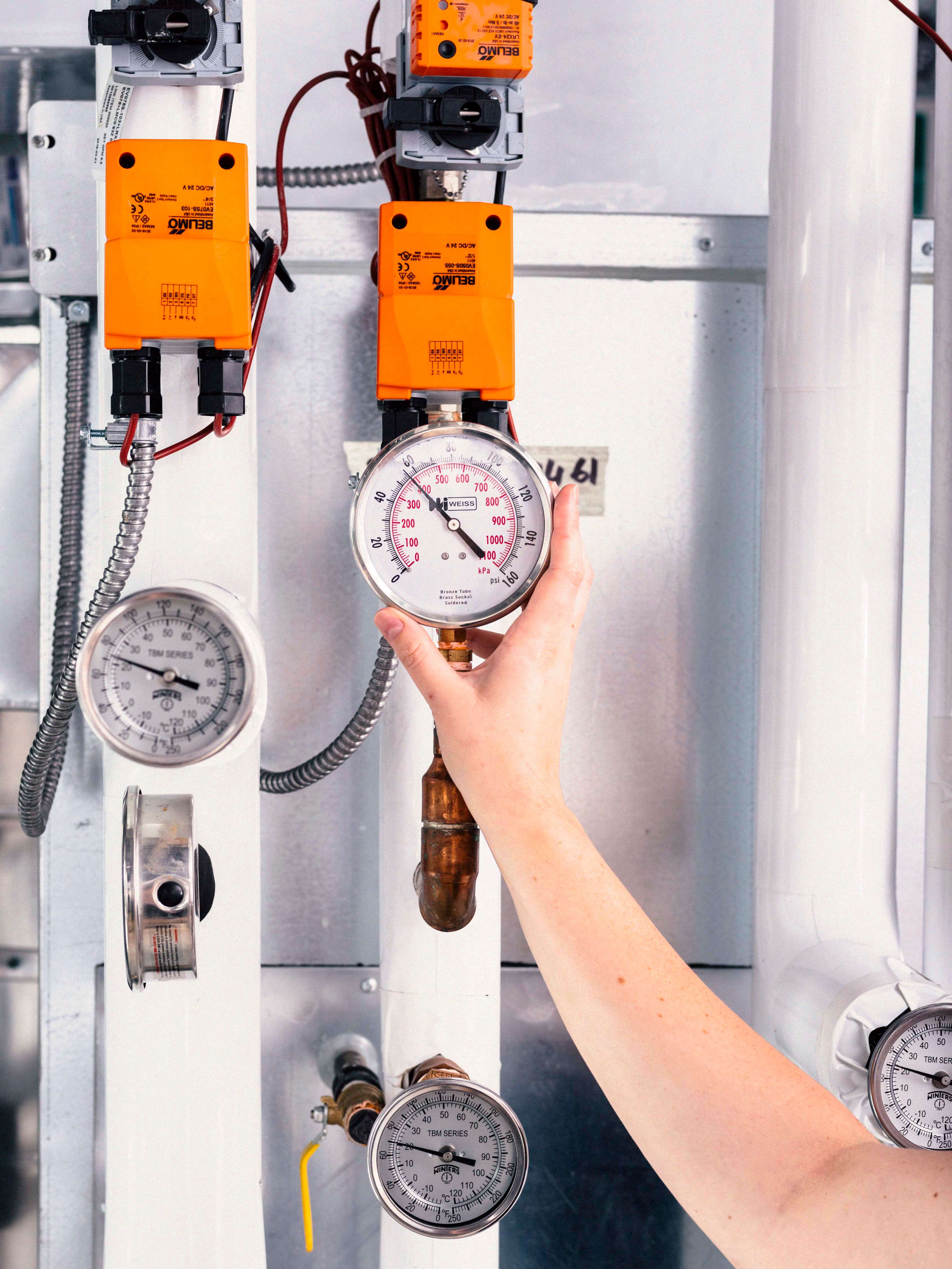 A photo of a hand reaching up to adjust a dial at the Twin Suites Lab at U of T's Sandford Fleming Building