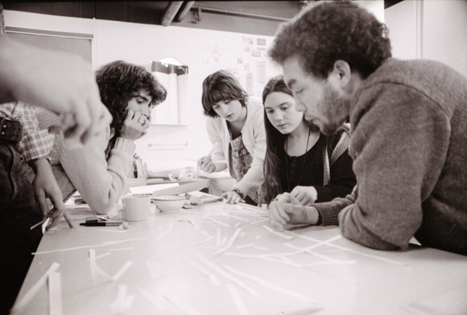 Four Cool School students gather around a table to work on a project together