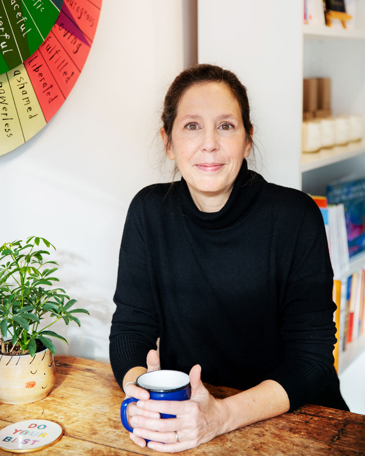 Kate Scowen sits at a table at the centre she established in Toronto to offer low-cost therapy sessions