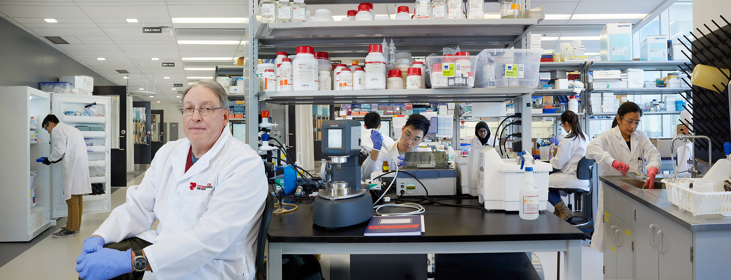 Prof. Paul Santerre in his lab at the Ted Rogers Centre for Heart Research, with his research team working in the background.