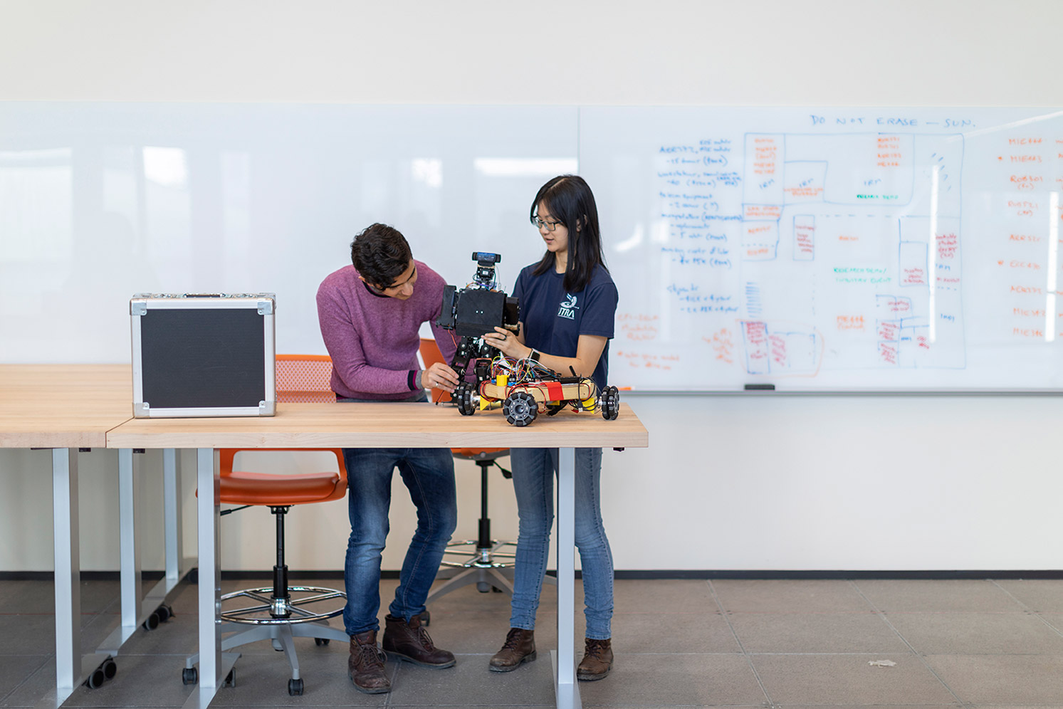 Two engineering students building a vehicle in the robotics lab