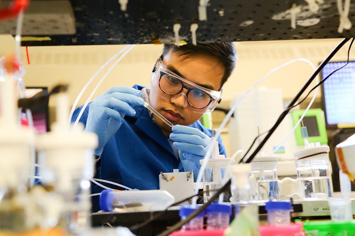 CERT team member Phil de Luna examining a test tube in a lab