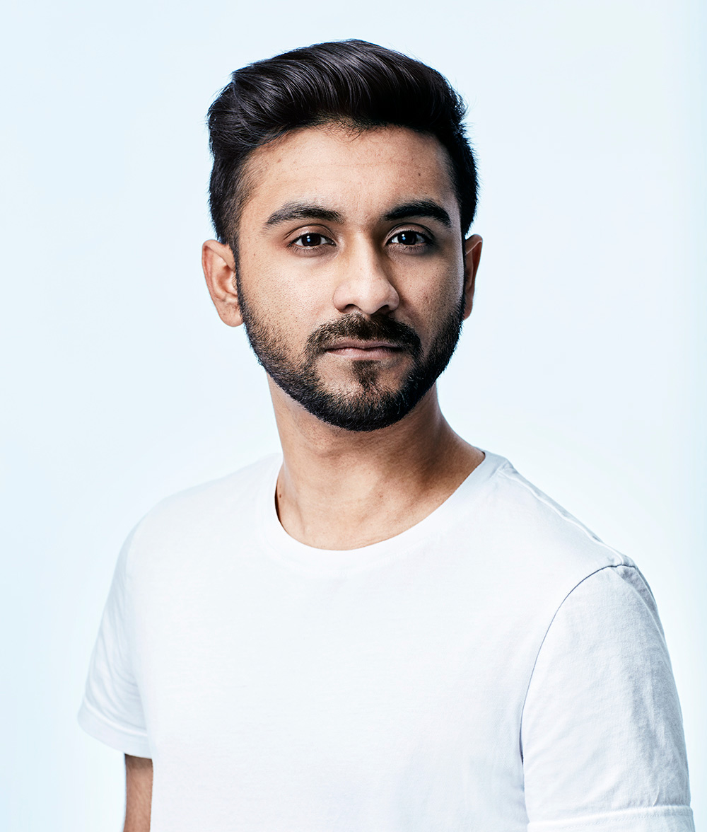 Photo of Tahmid Khan in a white T-shirt looking at the camera with a serious expression, shot in a studio against a bluish white background