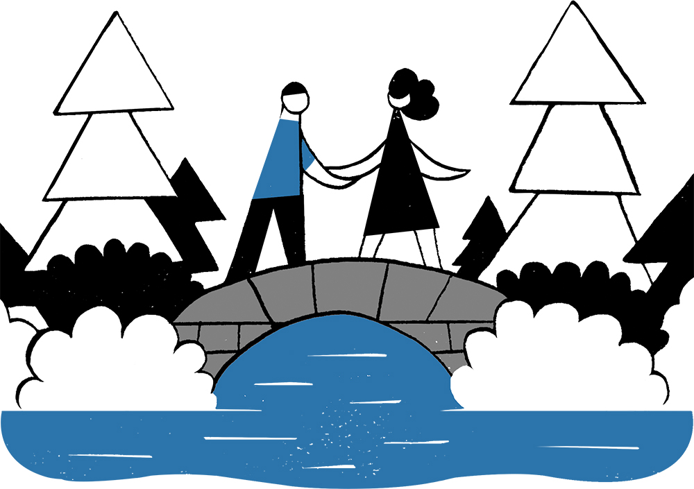 A man and woman holding hands and standing on a bridge over water