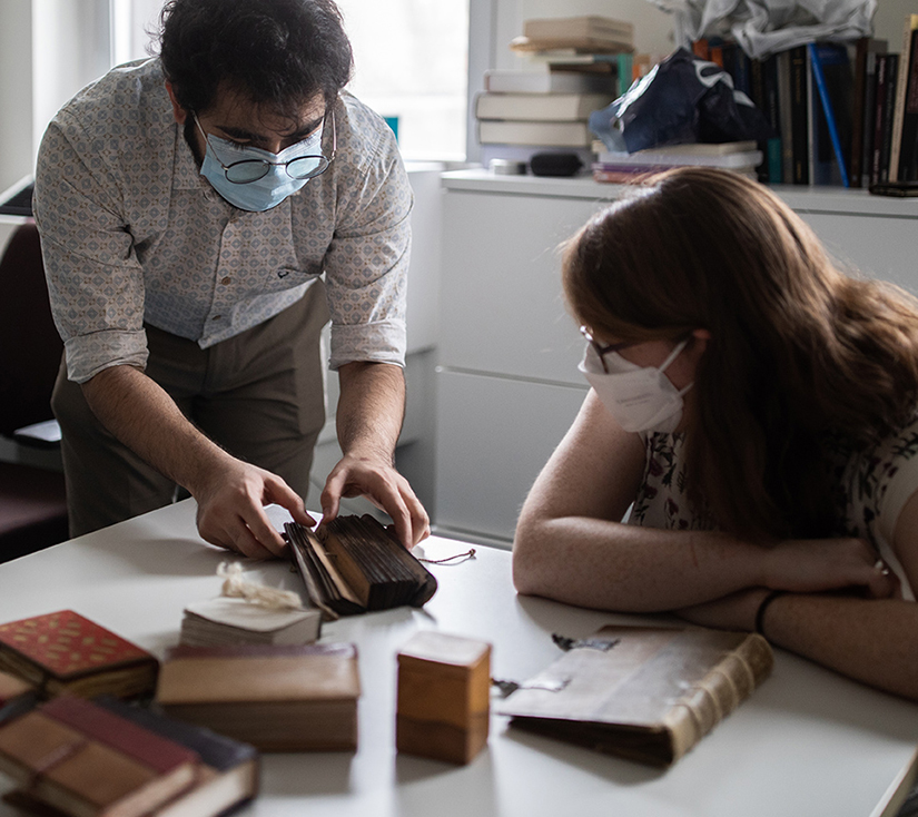 PhD students examine the binding of a palm leaf manuscript