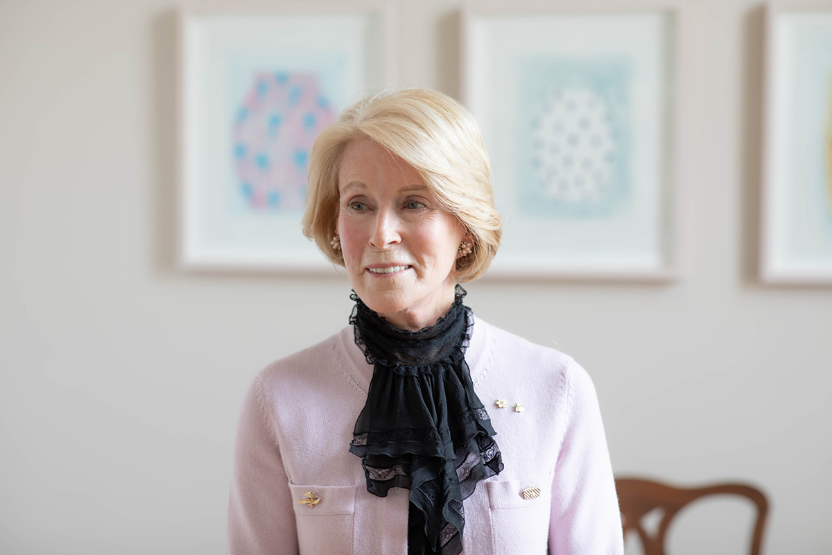 Indoor shot of Rose Patten, wearing a black sheer lace scarf and a light pink cardigan