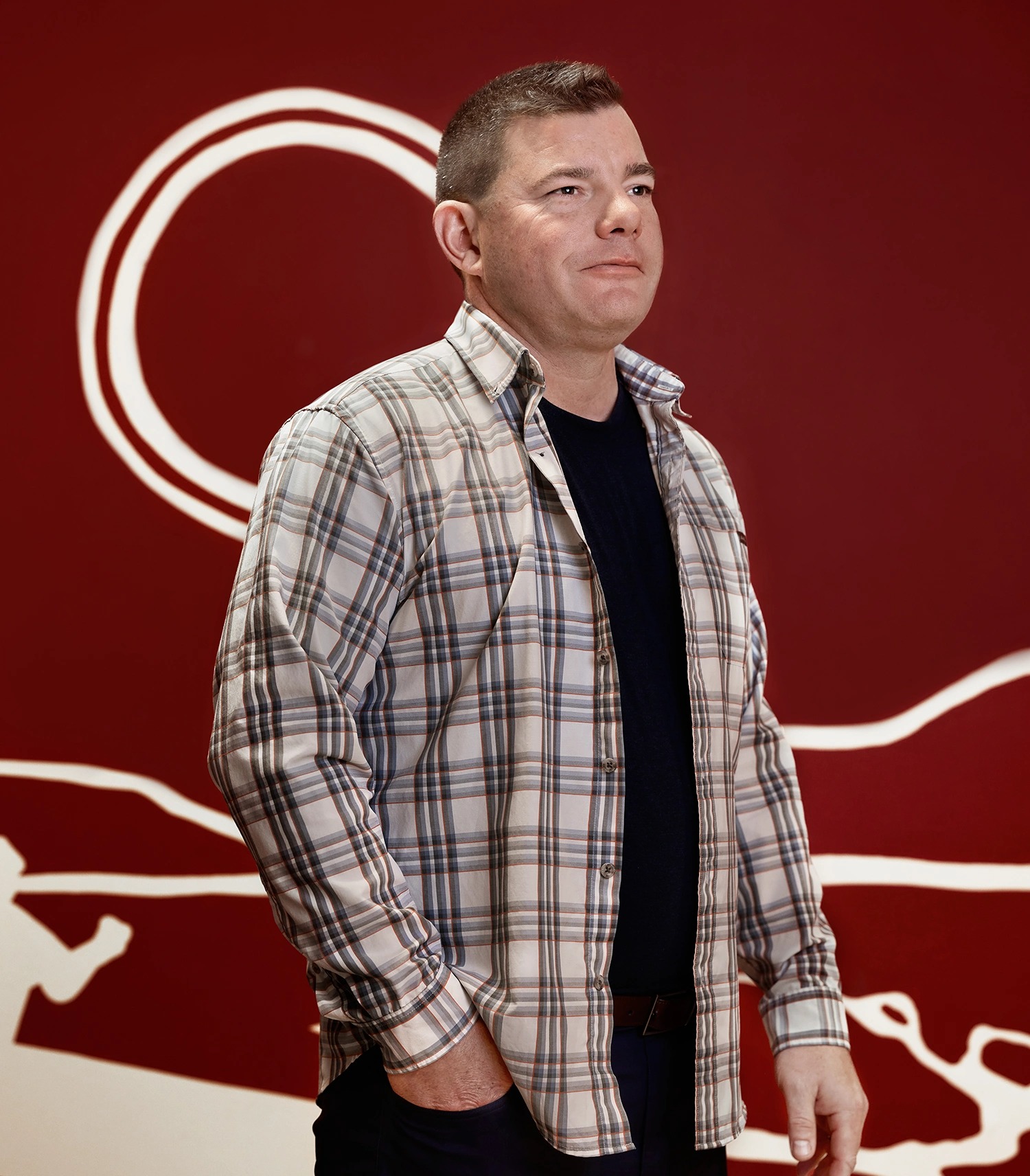 Professor Joe Brant against a dark red background with white line drawings